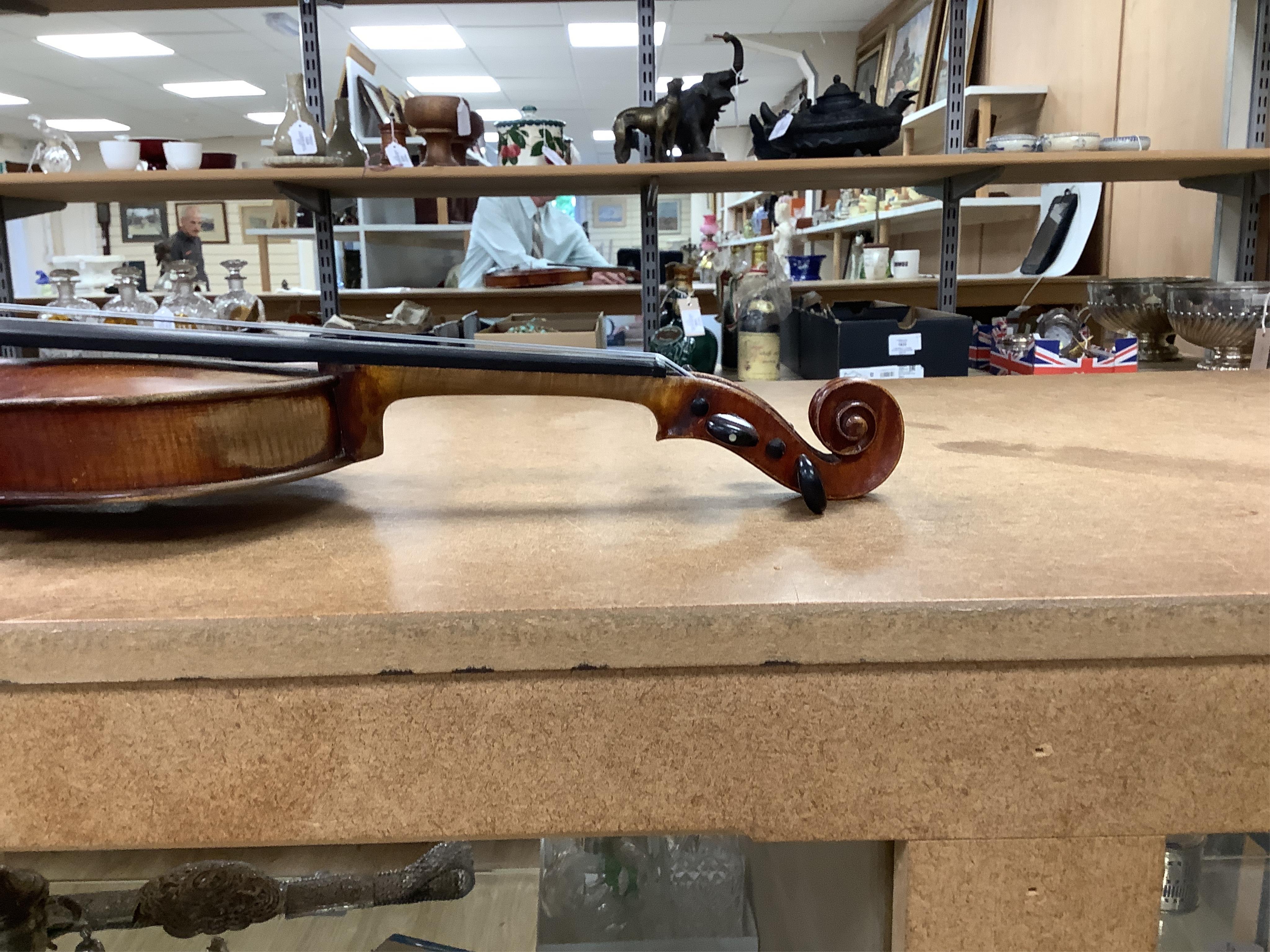 An early 20th century cased violin and cover, 60cm long